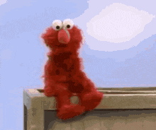 Elmo Hiding Shyly on a Balcony