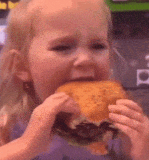 Cute Girl Savors Delicious Hamburger