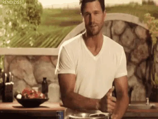 Handsome Man Undresses Loose Shirt While Cooking