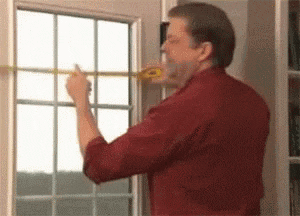 Man Measuring Window with Tape Measure
