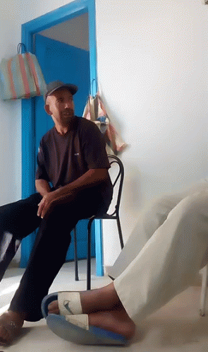 Man Sitting in Chair by Blue Door