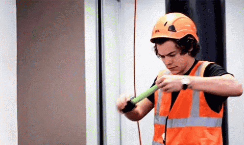 Harry Styles Stretching a Tape Measure