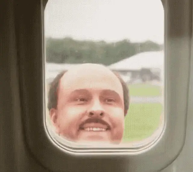 Man Smiling in Airplane Window