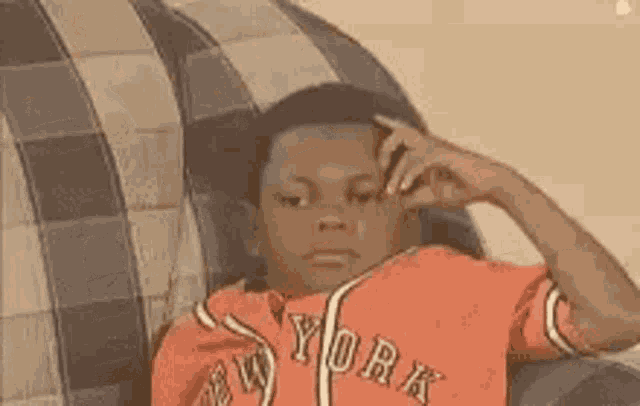 Boy in New York Shirt Thinking on Couch
