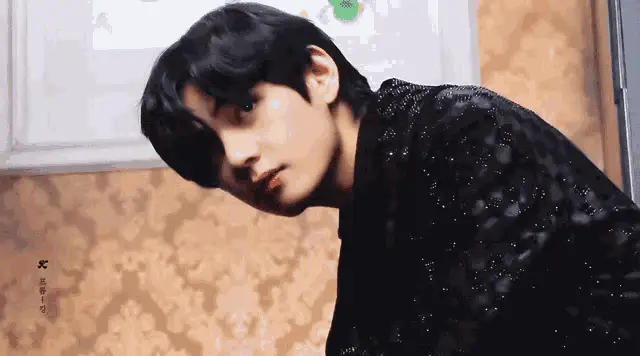Stylish Man in Sparkly Top Looks Down