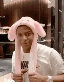 Man in pink bunny hat smiles and laughs