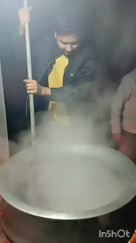 Man Stirring Large Steaming Pot