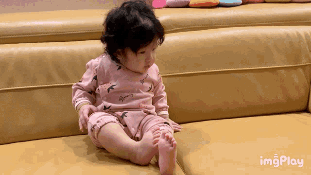 Cute Baby Girl Playfully Falls on Couch