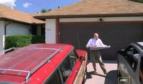 A GIF of a scene from Breaking Bad where Walter White throws a pizza on the roof of his house by accident